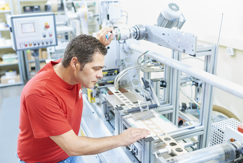 Illustration d'une découpeuse de la production. Machine avec bande sur laquelle les pièces découpées sont découpées selon les besoins des clients.