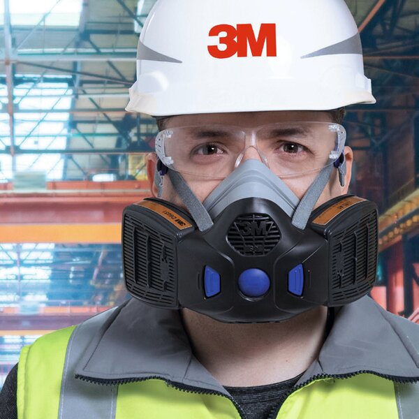 Mann mit 3M Helm, Halbmaske und Schutzbrille